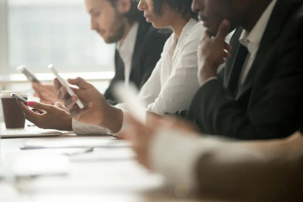 hombres de negocios mirando sus móviles