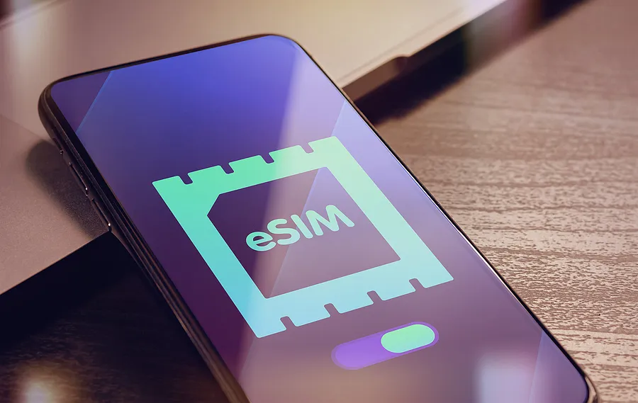 Un smartphone sobre la mesa en el que se ve el logotipo de la tarjeta eSIM