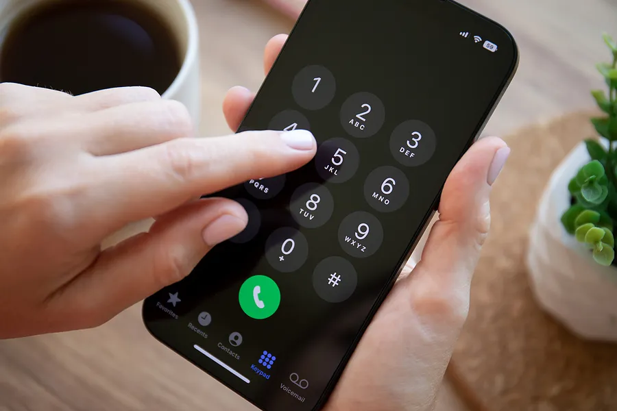 El dedo pulsando las teclas de un iPhone 14