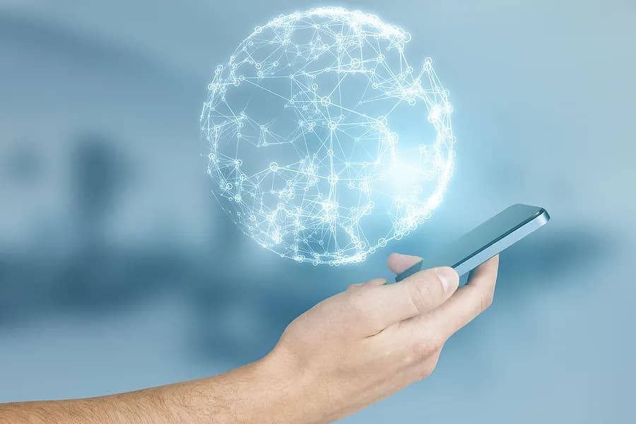 Mano que sostiene un iPhone con un planeta encima