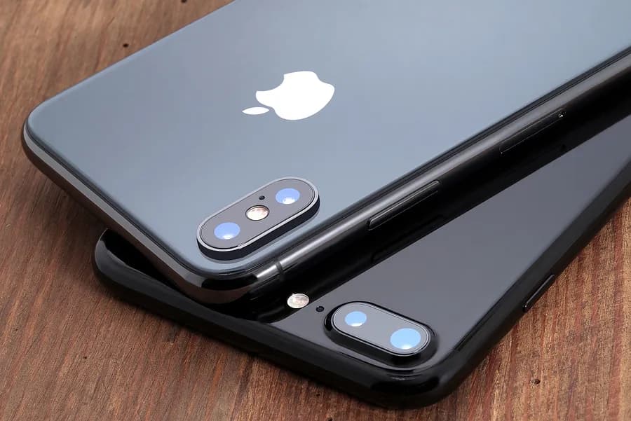 Dos iPhones de Apple de color gris, colocados boca abajo.