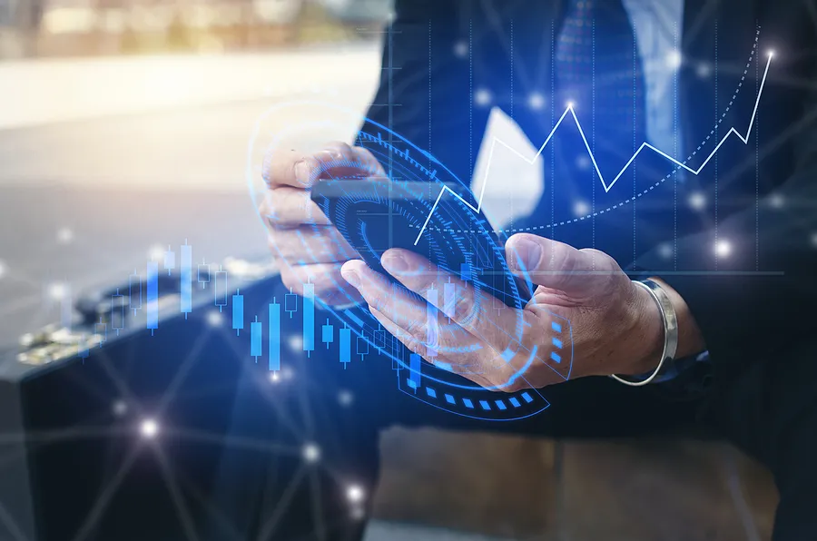 Empresario utilizando un smartphone con gráficos financieros digitales superpuestos