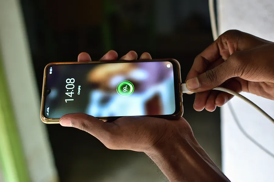 una persona que conecta un smartphone a un cargador