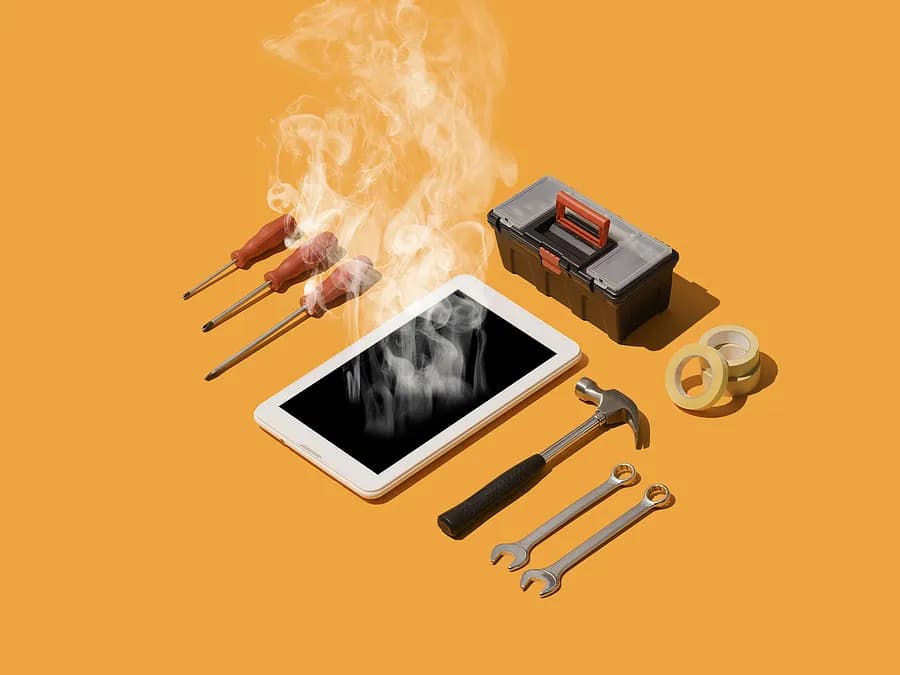 Un smartphone del que sale humo yace sobre una superficie naranja, rodeado de herramientas de reparación, entre las que se incluyen destornilladores, llaves inglesas, un martillo, cinta adhesiva y una pequeña caja de herramientas, lo que simboliza el sobrecalentamiento del teléfono y su reparación.