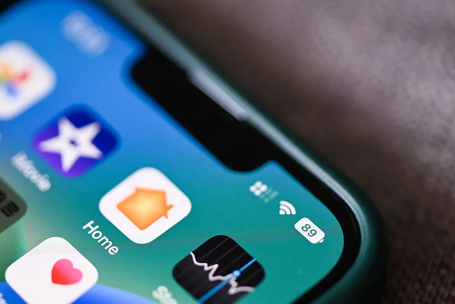 Primer plano de la pantalla de un iPhone en el que se ven los iconos de las aplicaciones y un indicador de batería al 89 %, que destaca el estado de la batería.